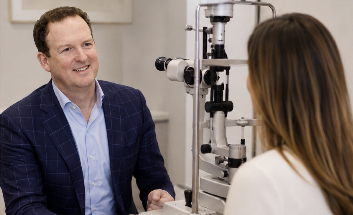 Dr Brendan Cronin smiling with a patient at the slit lamp during an eye examination.