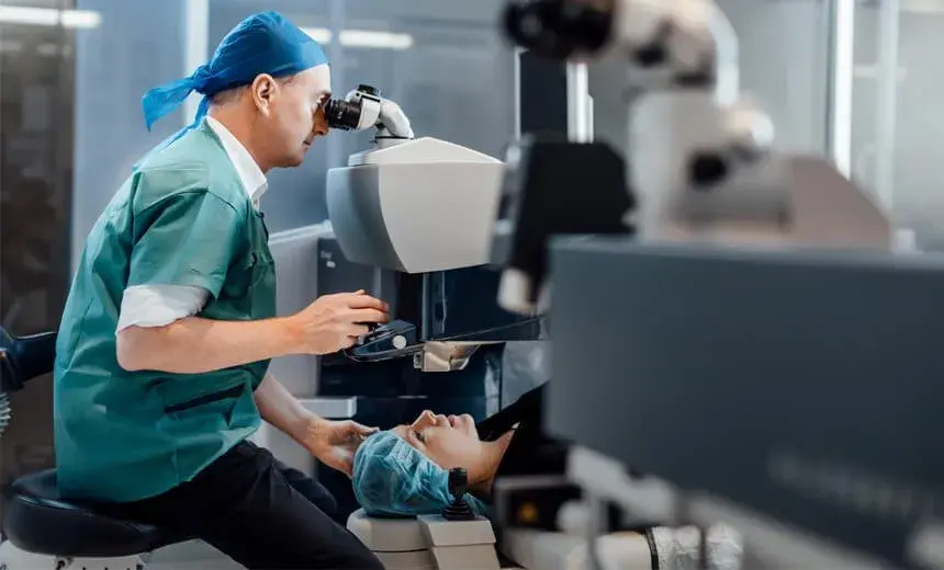 Ophthalmologist operating laser eye surgery on a patient in a clinical setting.