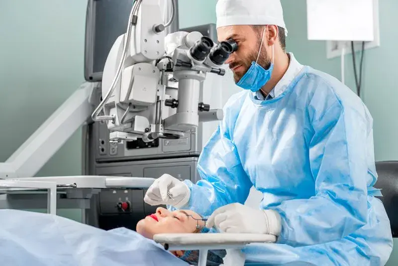 Doctor performing laser eye surgery on a patient in a clinical setting.