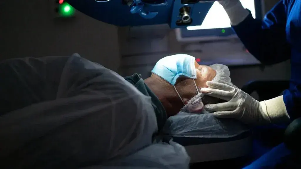 A patient lying on an operating table while undergoing laser eye surgery.